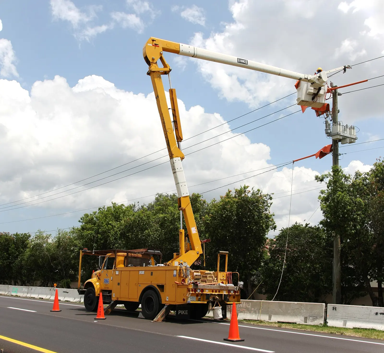 A utility crew in a bucket truck repairs a power line in neighboring Weston.